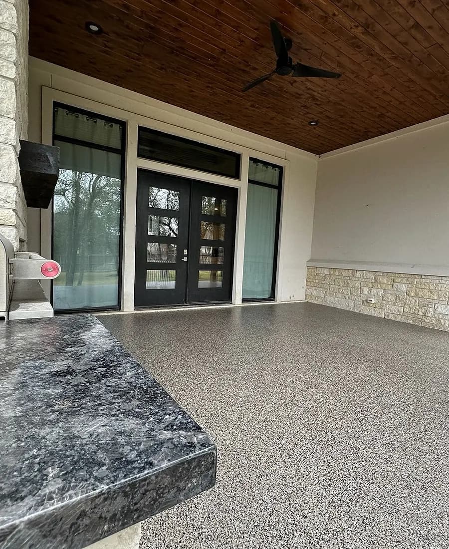 Covered patio with an outdoor kitchen and stone columns, finished with a Heritage flake coating